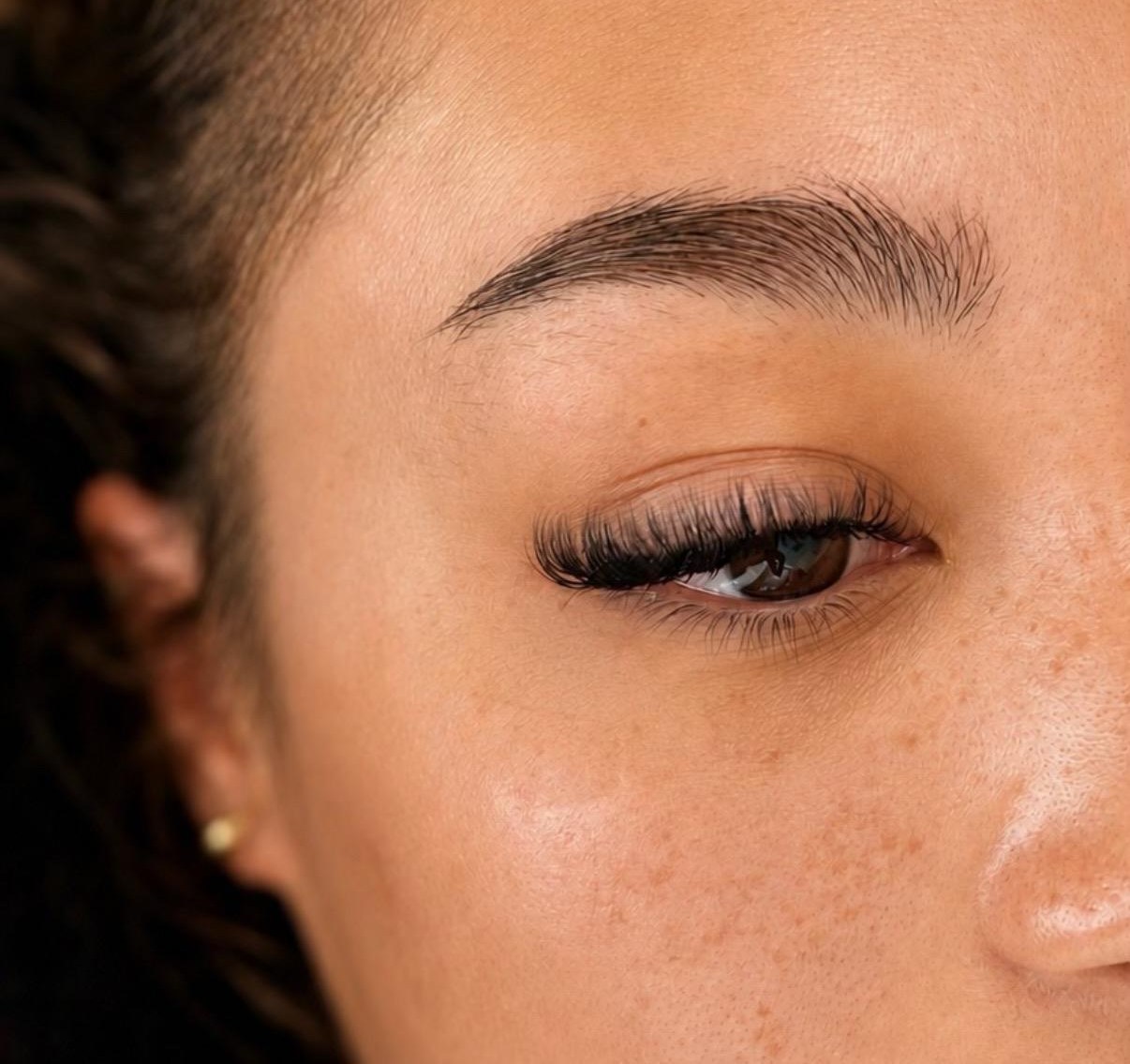 Nahaufnahme einer natürlich gestylten Augenbraue mit Wimpernverlängerung